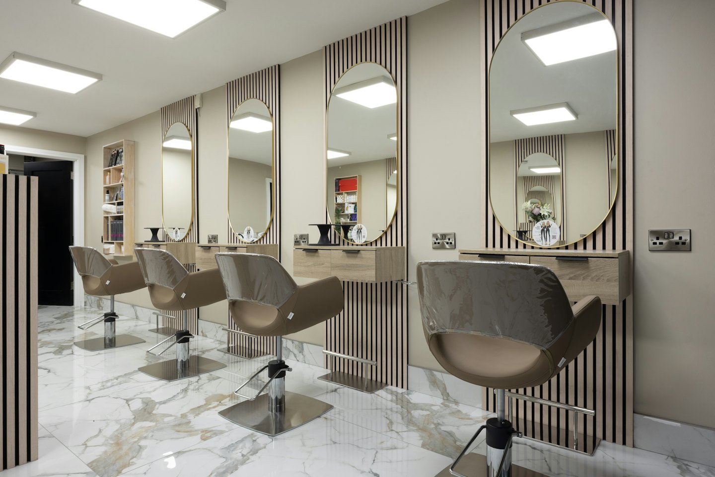 Puste nowoczesne salon fryzjerski z stanowiskami do stylizacji i marmurowymi podłogami.